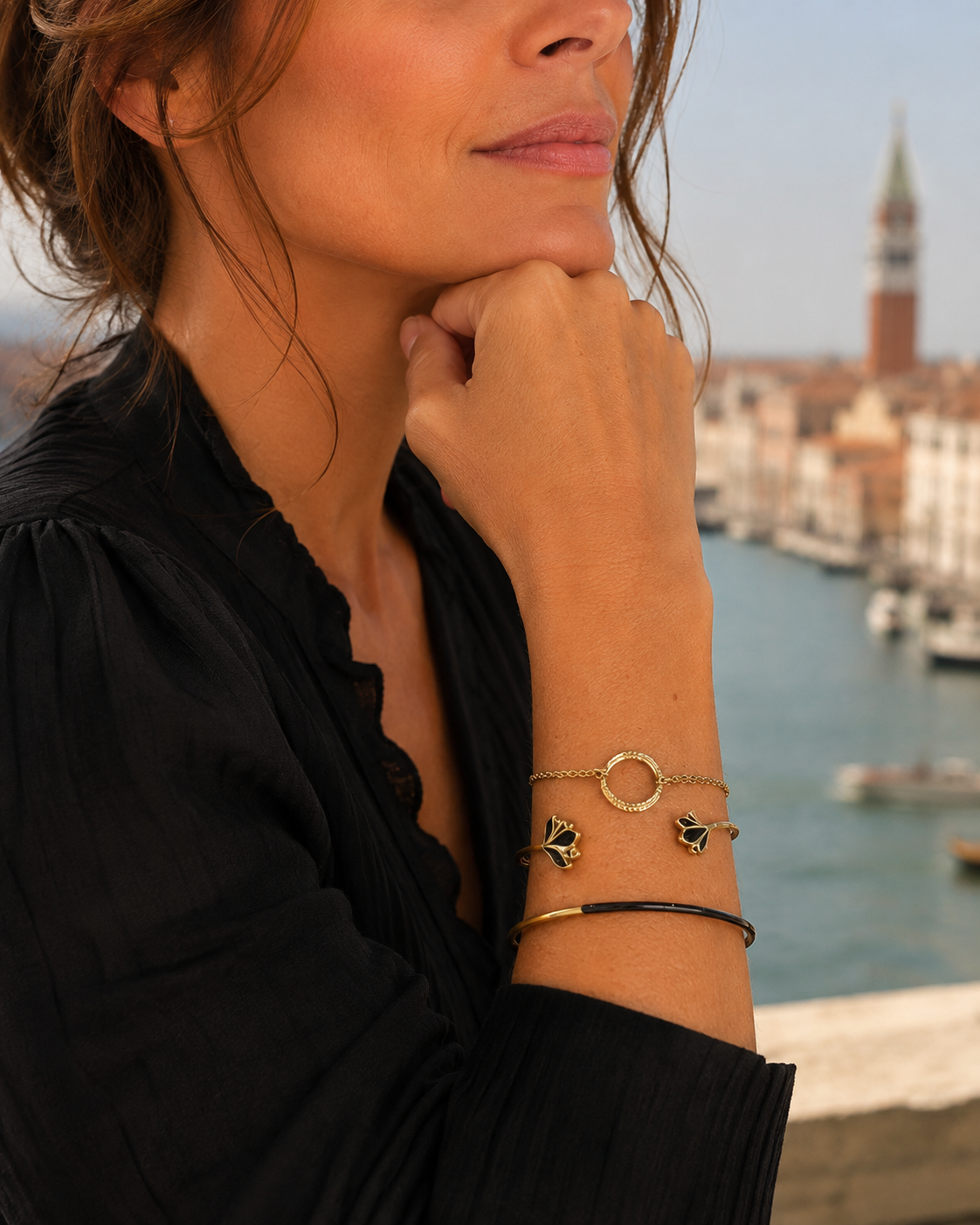 gros plan sur la boucle d'oreilles chics et élégantes Venezia dorée avec des détails laqués noirs en acier inoxydable 