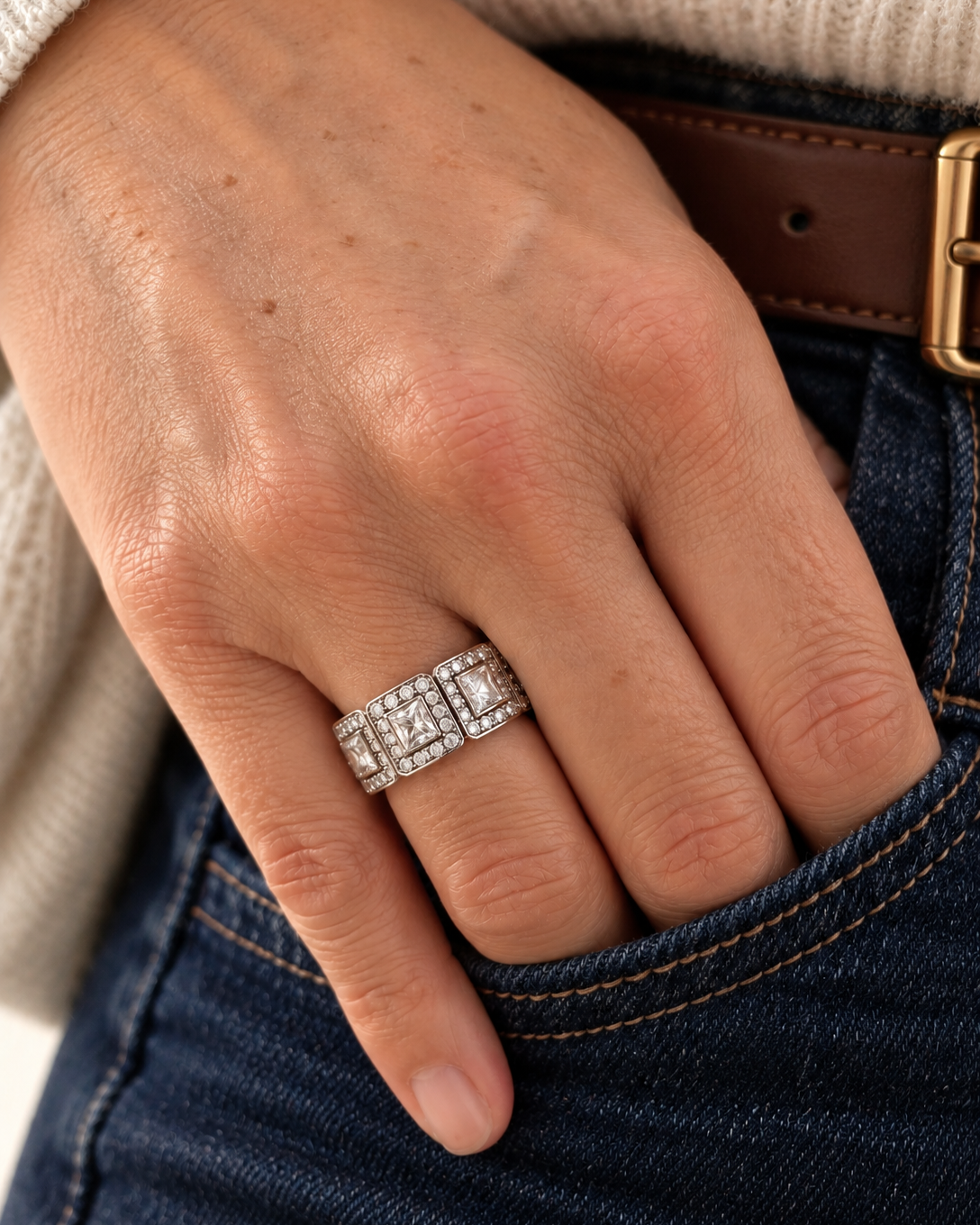 Bague Charleston argentée pour femme en acier inoxydable ornée de zircons, portée avec un jean bleu marine, design géométrique inspiré de l’Art déco.
