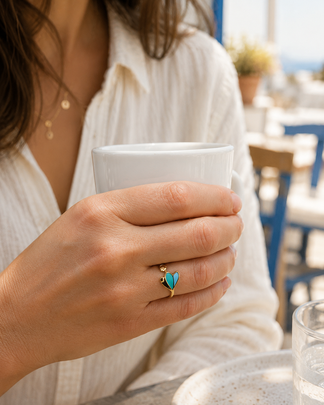 Photo de la bague dorée Elena en acier inoxydable, portée. on distingue la finesse des motifs et les nuances colorées vert et turquoise.