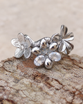 Bague fleur Un matin au jardin en acier inoxydable finition argentée, ornée de fleurs en relief et de deux zircons lumineux.