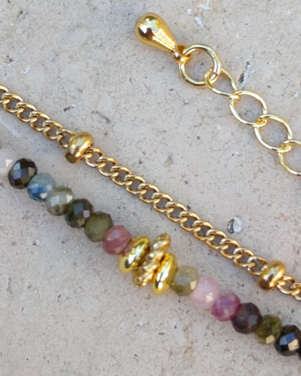Détail du bracelet double rang Monet en tourmalines naturelles multicolores, avec chaîne à petites billes, éléments dorés et chaînette d’extension en plaqué or 18 carats.