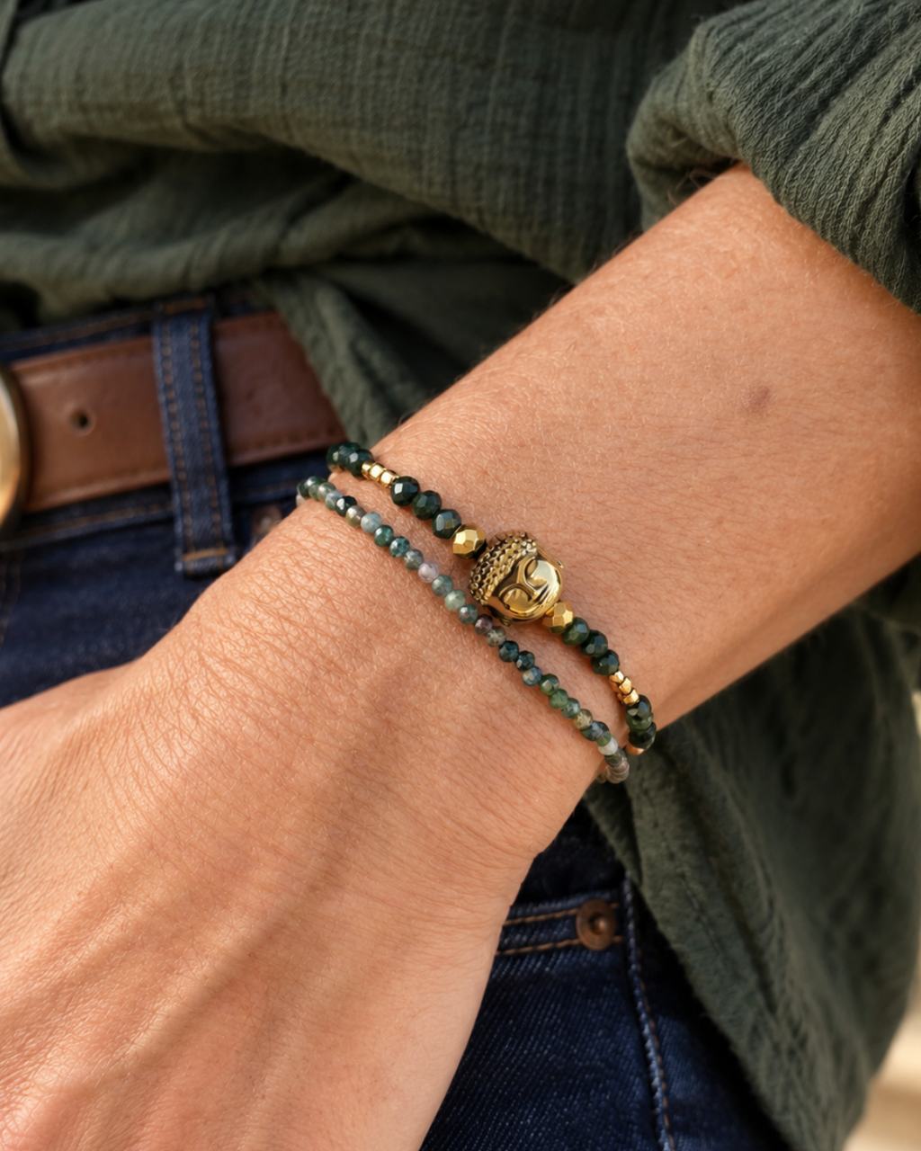 Bracelet Namasté porté au poignet, en agates indiennes et hématites dorées, avec Bouddha doré et fermoir plaqué or 18 carats.