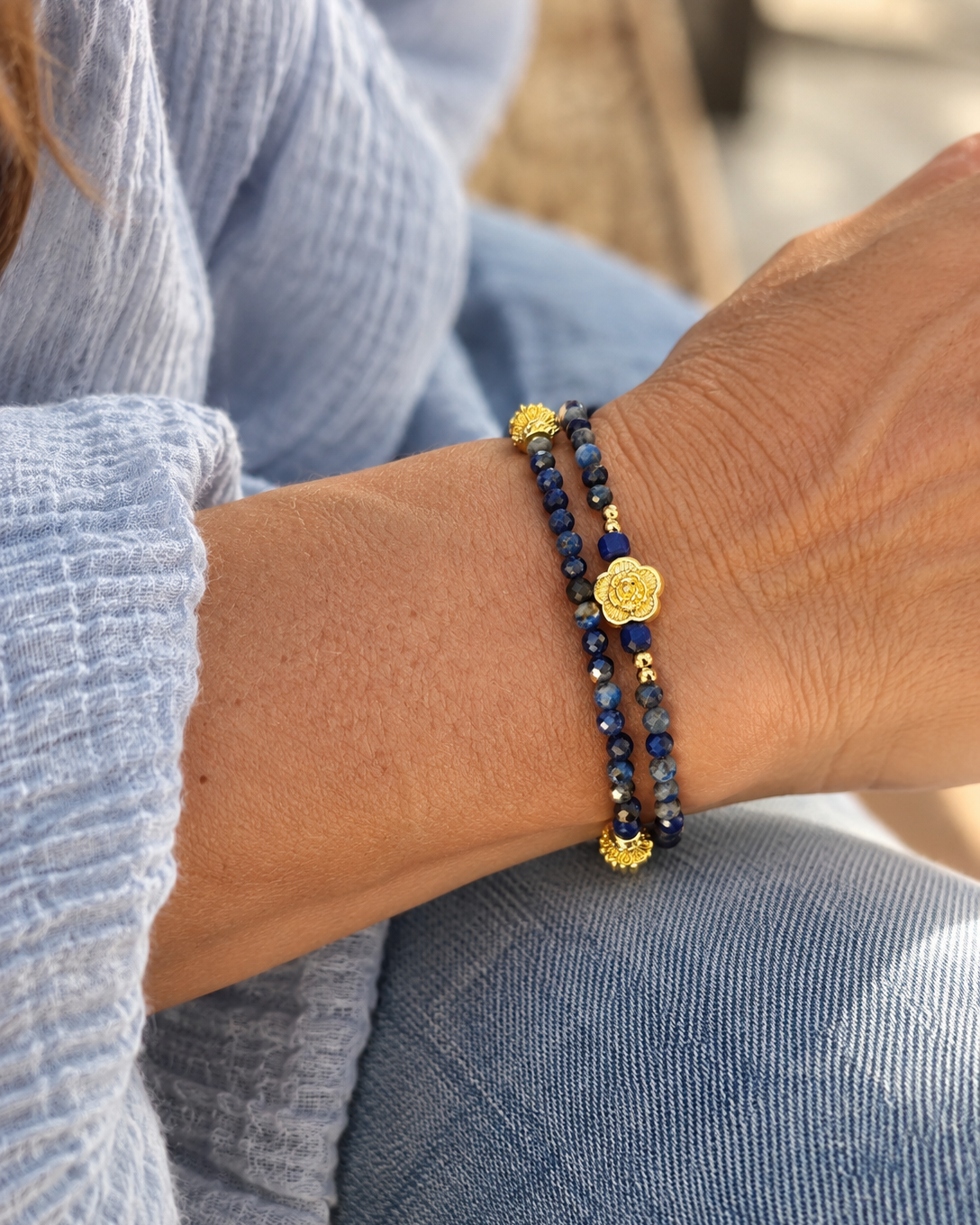 Bracelet double rang Songe d’une nuit d’été en lapis-lazuli et plaqué or 18 carats, porté au poignet d’une femme.