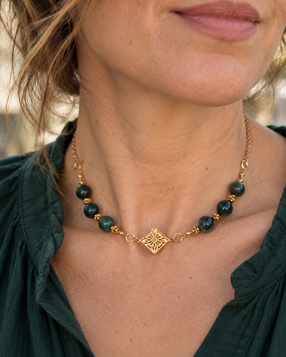 Collier ras-du-cou Arabesque créé et assemblé en France par Yselia, composé de perles rondes en agate verte naturelle, de détails en plaqué or 18 carats et d'un médaillon central ajouré à motif floral.
