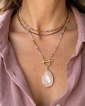 Collier femme trois rangs Juste avant l'aube porté, composé de rubis, pierre de soleil noire, hématites dorées et pendentif en quartz rose avec plaqué or 18 carats.