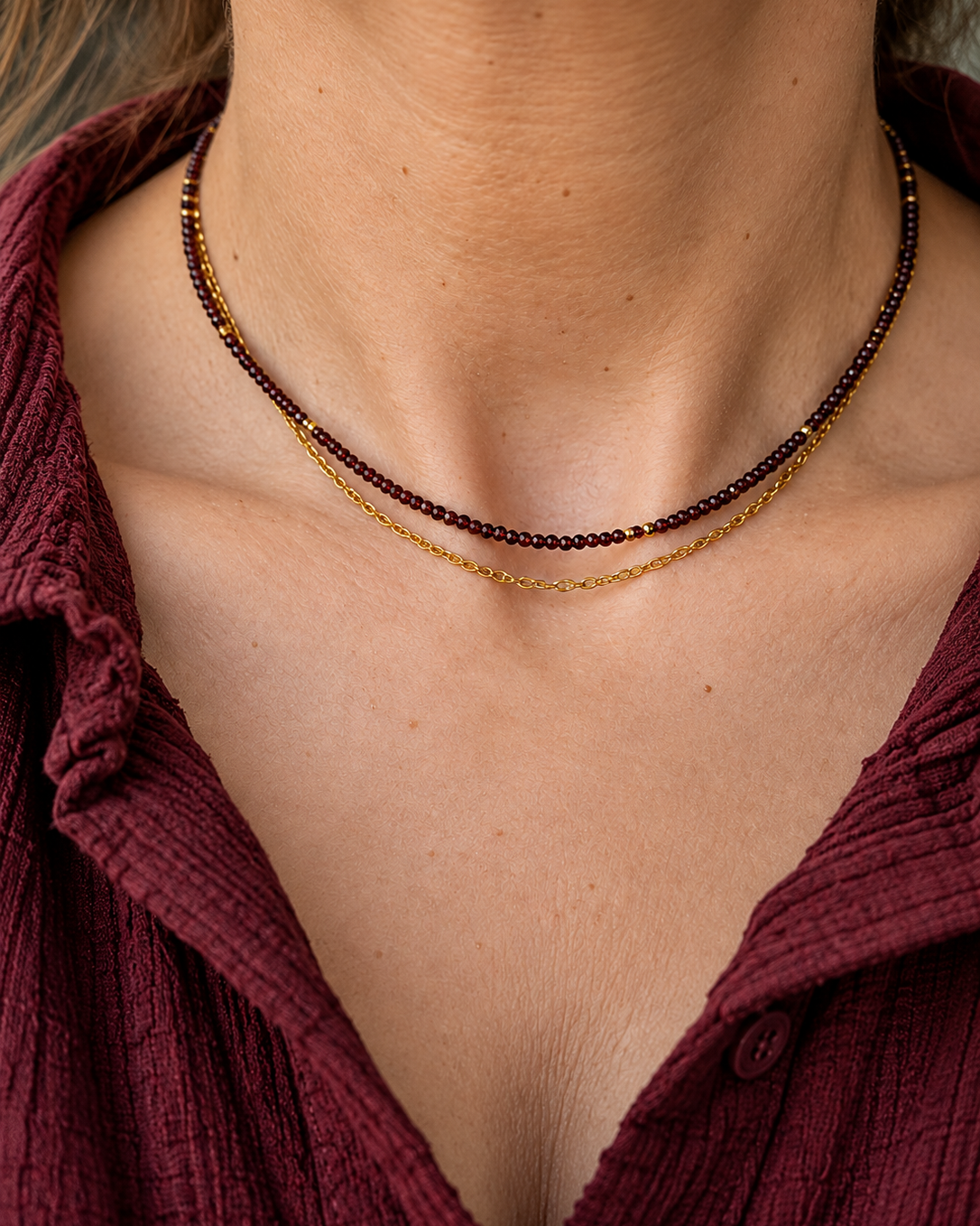 Détail des deux rangs du collier Les Heures Pourpres, associant de petites perles de grenat naturel facettées, des hématites dorées et une fine chaîne dorée.