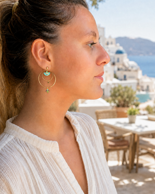 photo des boucles d'oreilles créoles dorées Santorin en acier inoxydables avec touches de bleu vert et turquoise.