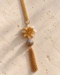 Gros plan du sautoir Hanami en agate  naturelle, avec pendentif fleur en plaqué or 18 carats et fines chaînes dorées. Bijou féminin assemblé à la main en France.