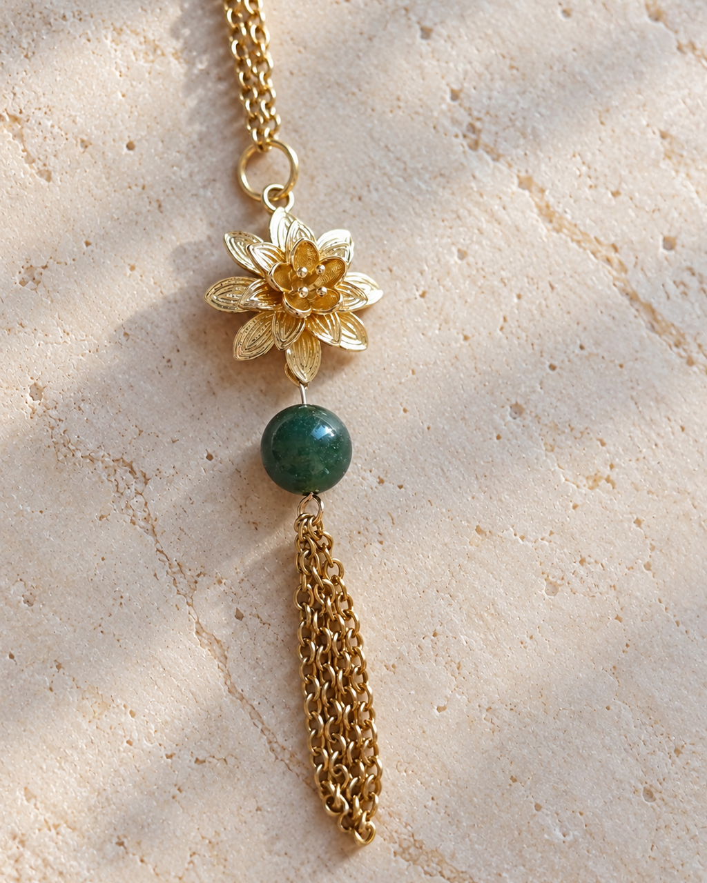 Gros plan du sautoir Hanami en agate indienne naturelle, avec pendentif fleur en plaqué or 18 carats et fines chaînes dorées. Bijou féminin assemblé à la main en France.
