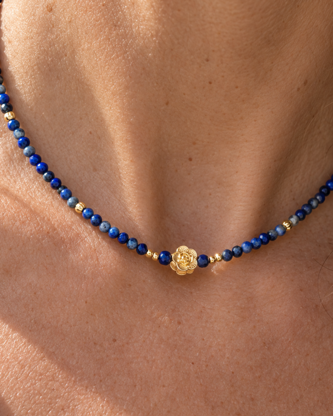 détail du médaillon finement travaillé du collier ras du cou en lapis lazuli et plaqué or 18 carats.