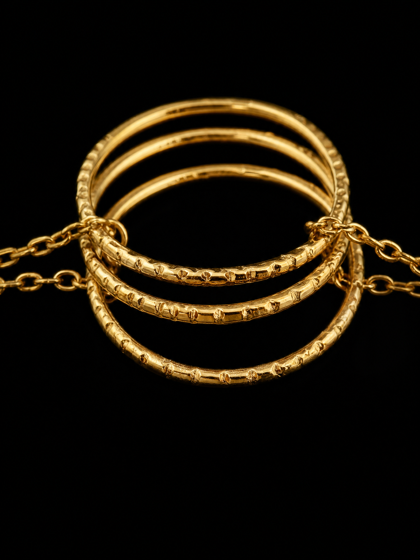 Photo en gros plan des anneaux dorés et texturés du bracelet en acier inoxydable Echo de la collection Venezia de Yselia bijoux.