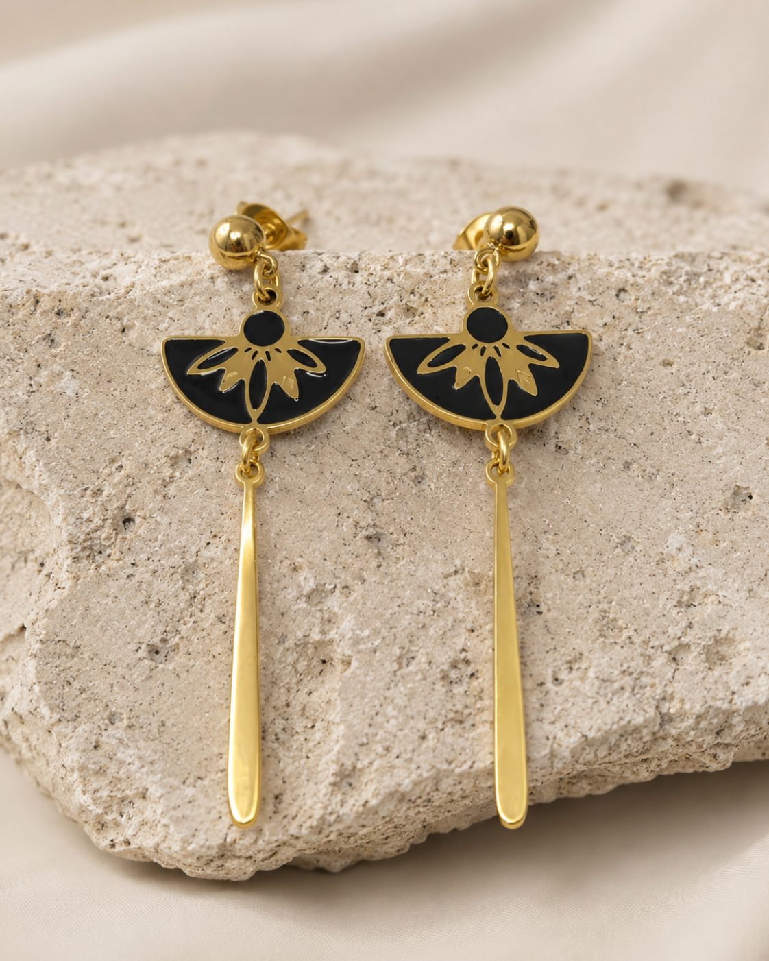 photo de la paire de boucle d'oreilles Palazzo en acier inoxydable doré. gros plan sur les motifs laqués noirs 