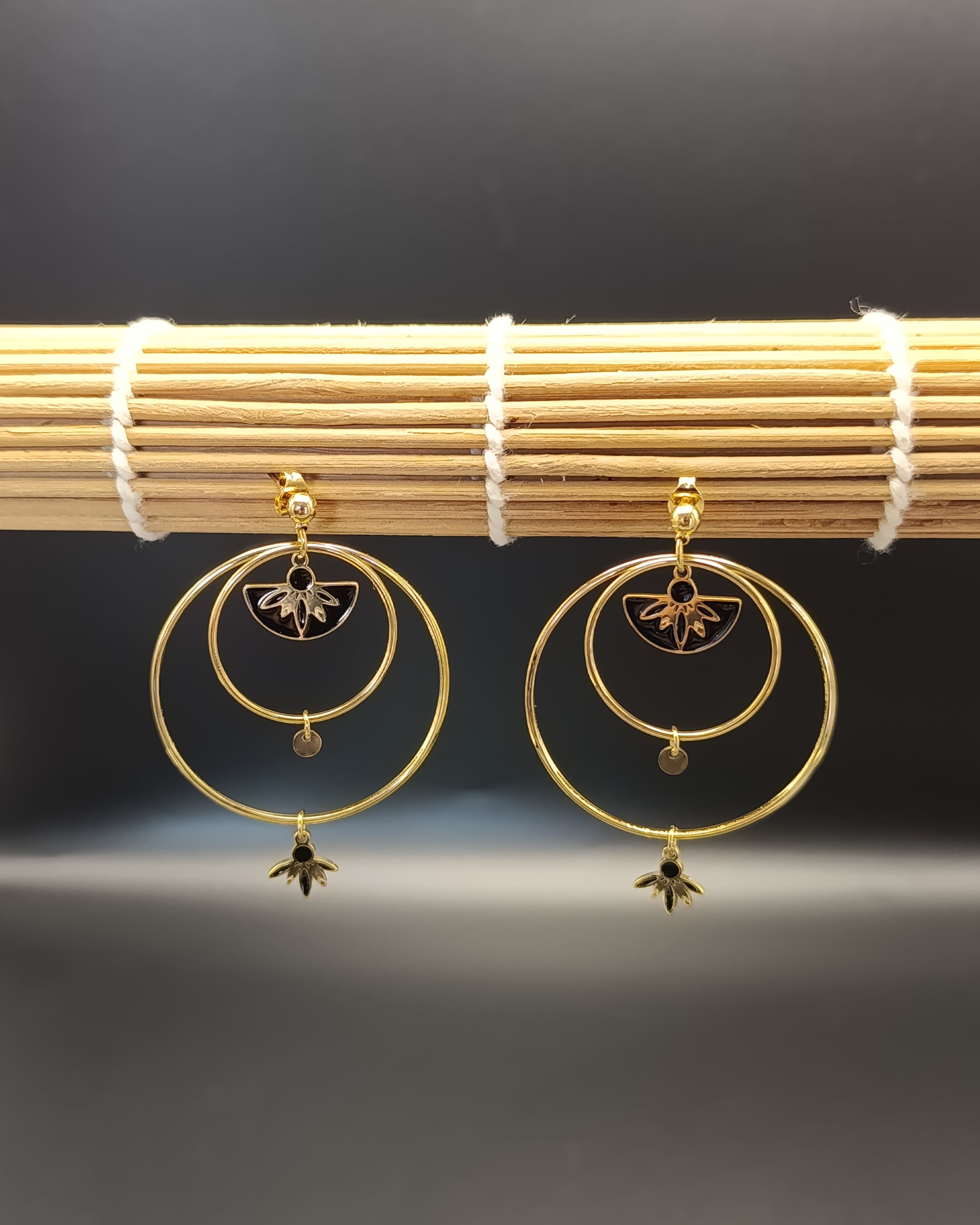 photo de la paire de boucles d'oreilles Venezia en acier inoxydable dorée avec des détails laqués noirs