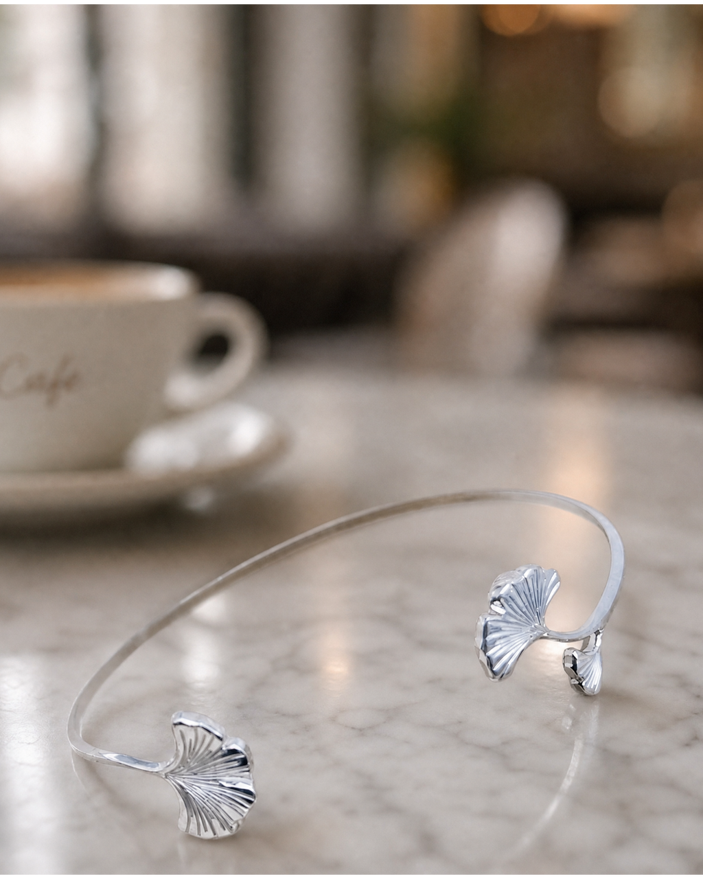 bracelet ginkgo argent posé sur une table 