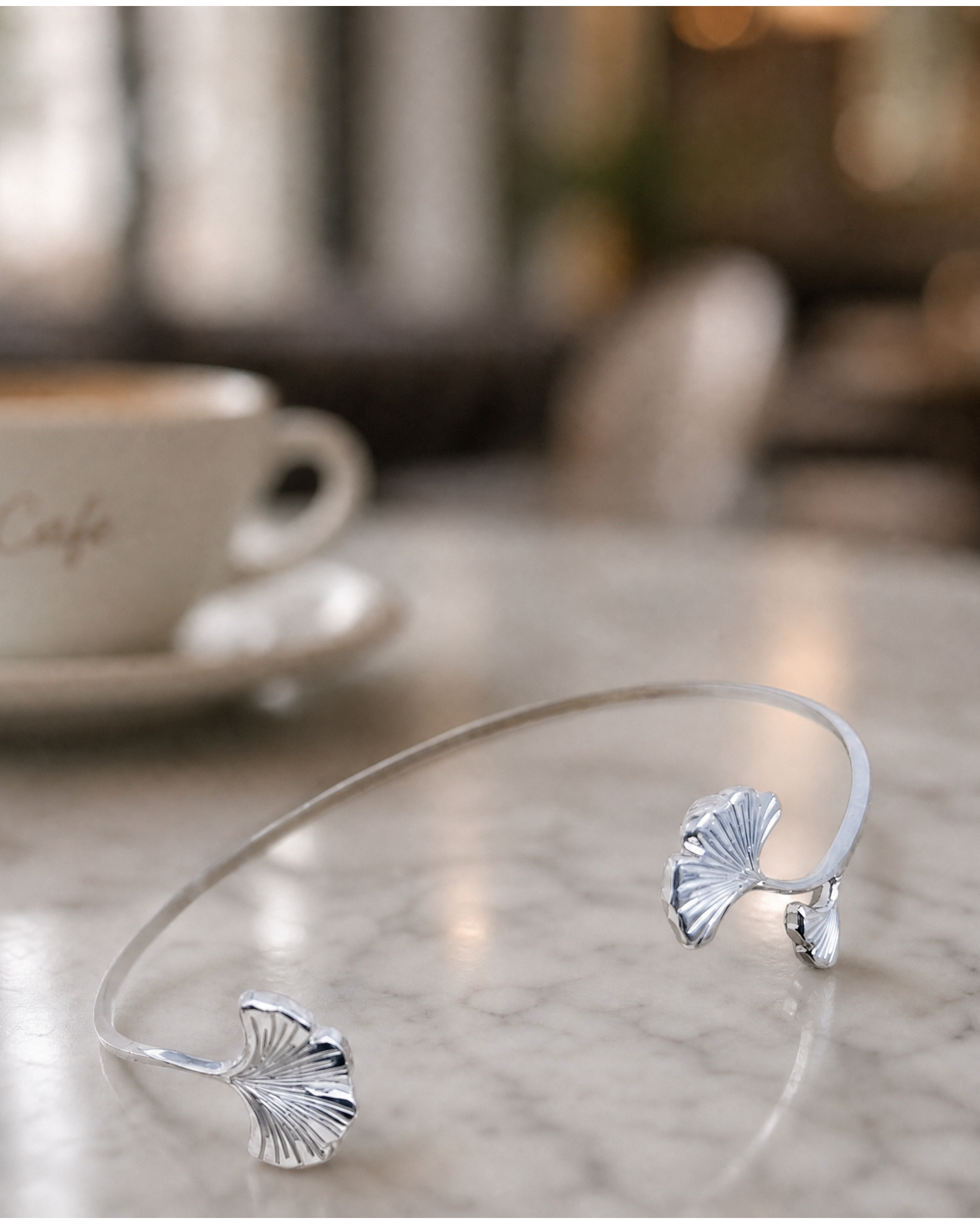 bracelet ginkgo argent posé sur une table 