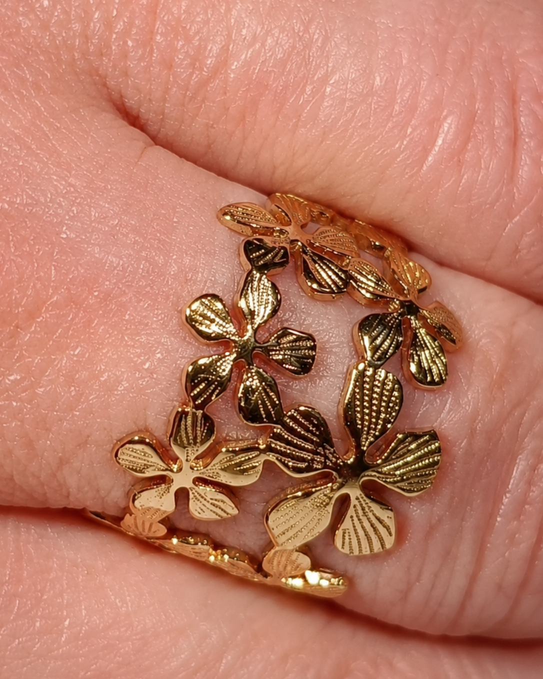 gros plan sur les détails et les etites fleurs de la bague Mélusine en acier inoxydable finition dorée PVD, résistante à l'eau et à la vie quotidienne. détails de la finesse des motifs. bague Yselia de la collection "A fleur de peau"