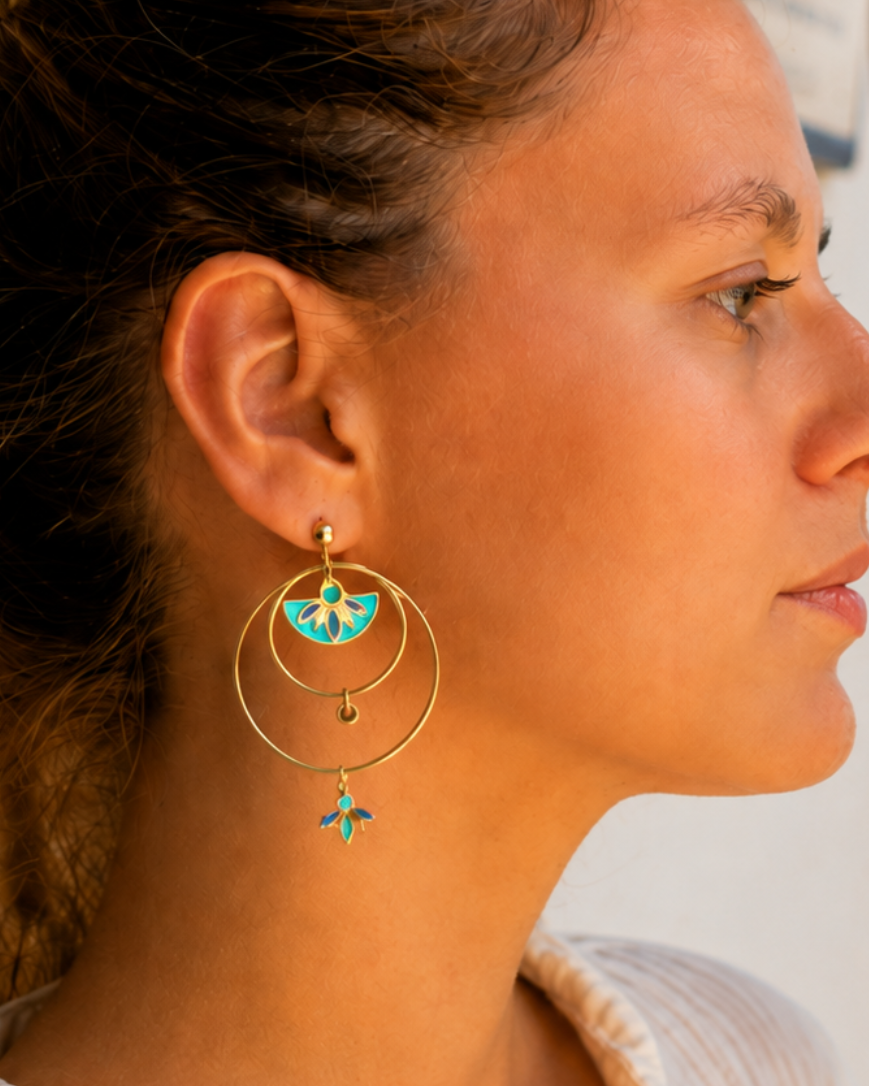 photo des boucles d'oreilles créoles dorées Santorin en acier inoxydables avec touches de bleu vert et turquoise.