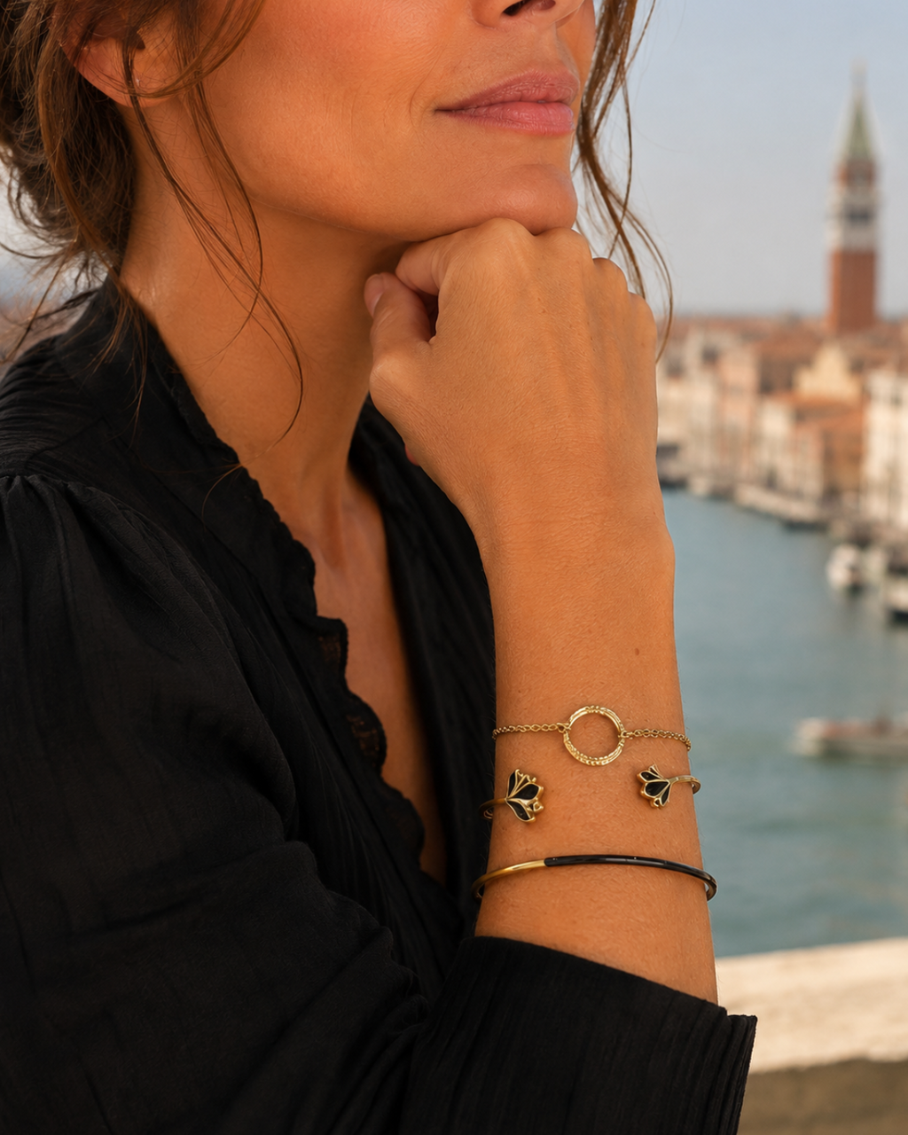 photo en gros plan du bracelet rigide type jonc, en acier inoxydable doré et noir laqué  , porté avec d'autres bracelets de la  collection  Venezia de la boutique Yselia bijoux