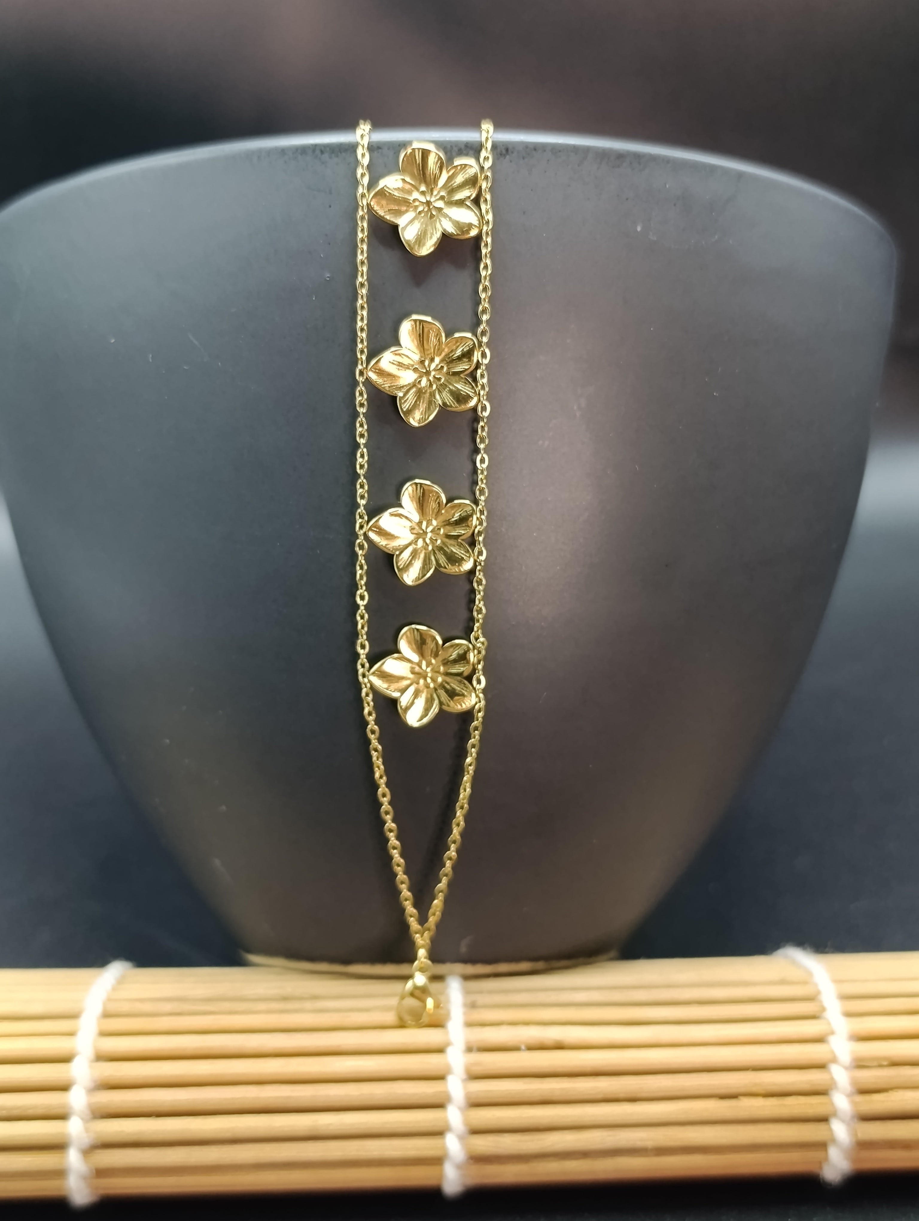 zoom sur le bracelet Juliette en acier inoxydable pvd, résistant à l'eau et à l'usure de la vie quotidienne. Finition dorée. composé d'un double rang et de petite fleurs, très élégantes. un bracelet de la collection A fleur de peau d'yselia.