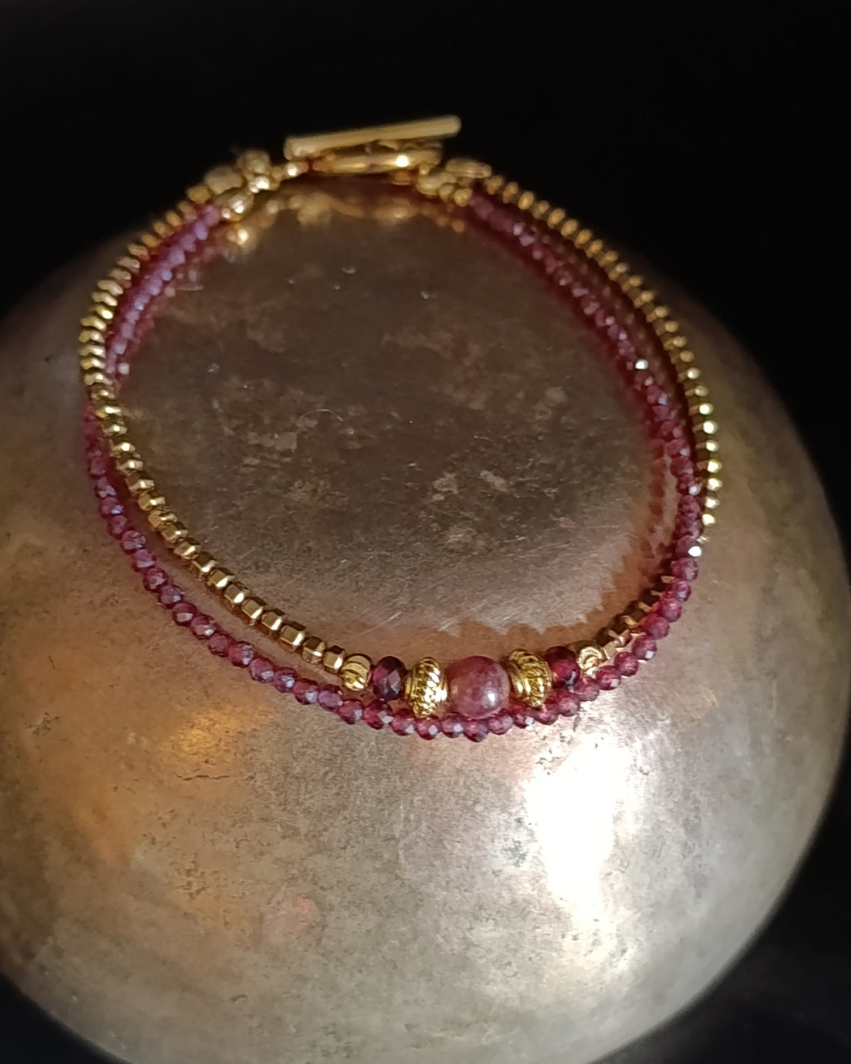 photo d bracelet double rang Isadora composé d'un rang de perles en rubis naturelles et d'un rang en hématites dorées , quelques perles travaillées en plaqué or 18 carats , de 2 grenat et une spinelle rose.