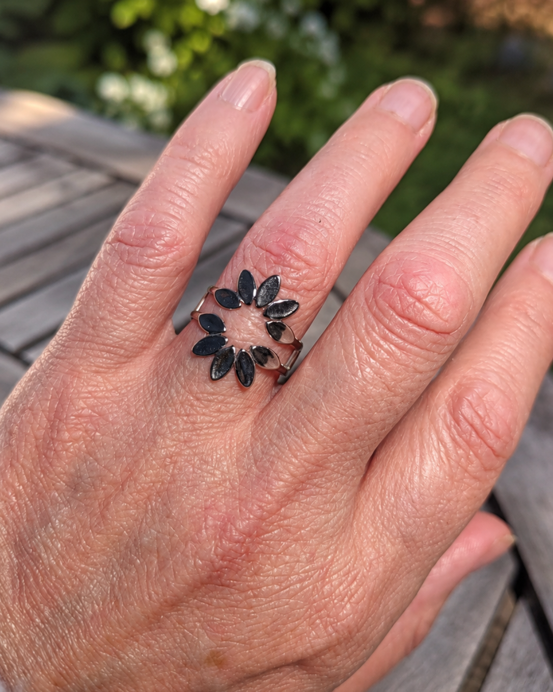 gros plan sur la bague en acier inoxydable finition argent pvd, resistante a l'eau et à l'usure de la vie quotidienne.une bague élégante avec sa petite corolle de pétales. yselia bijoux