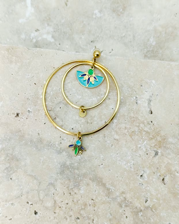 gros plan sur une des boucles d'oreilles dorée avec du bleu du vert et du turquoise en acier inoxydable 